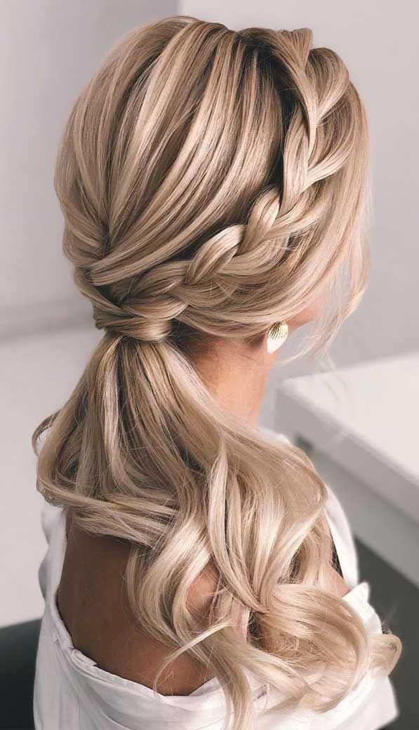 Back view of a woman with a blonde braided ponytail in a softly lit, light-toned interior, calm editorial mood